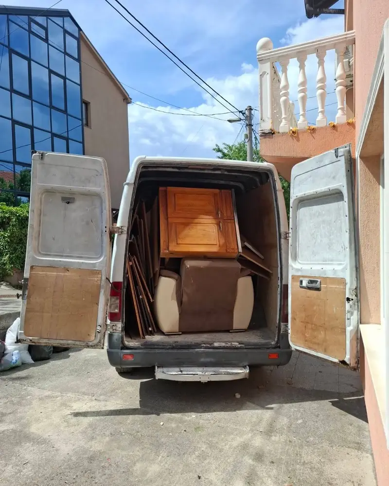 Kombi natovaren drvenim ormarom i stolicama