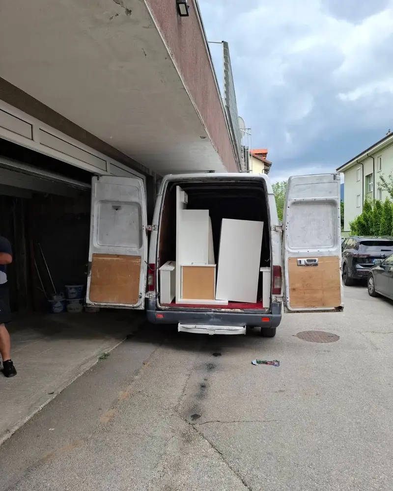 Kombi s bijelim pločama namještaja ispred zgrade